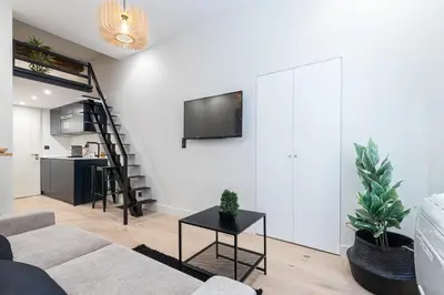 a living room with a couch and a tv on a wall at Studio Duplex - Vieux Nice - 100m de la mer in Nice