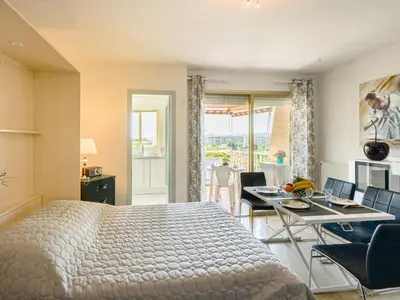 a bedroom with a bed and a table and chairs at Studio Le Baccara by Interhome in Cagnes-sur-Mer