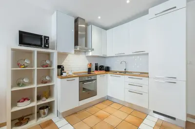 a kitchen with white cabinets and a microwave at 8 CONDAMINE - Stylish in Old Town - 2 pièces - 300m de la mer in Nice