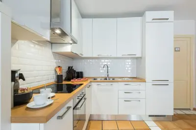 a kitchen with white cabinets and a sink at 8 CONDAMINE - Stylish in Old Town - 2 pièces - 300m de la mer in Nice