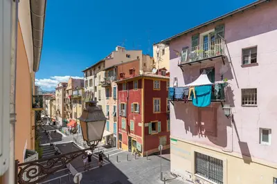 a group of people walking down a street between buildings at 8 CONDAMINE - Stylish in Old Town - 2 pièces - 300m de la mer in Nice