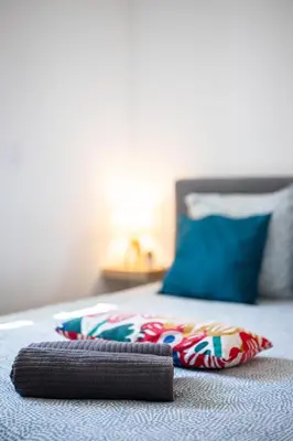 a bed with two pillows on top of it at Cosy & Chill Appartements - 10 min de la mer - Jardin, Netflix, terrasse, fibre & parking in Cagnes-sur-Mer