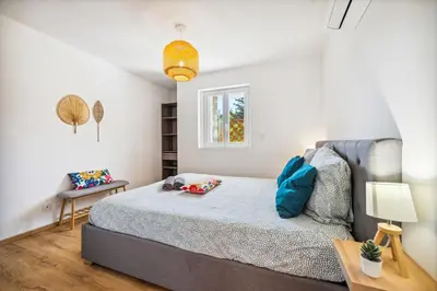 a bedroom with a bed and a table at Cosy & Chill Appartements - 10 min de la mer - Jardin, Netflix, terrasse, fibre & parking in Cagnes-sur-Mer