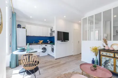 a kitchen with white cabinets and a table and chairs at Lovely Apartment City Center Heart - AC in Nice