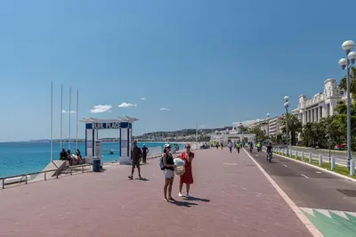 a group of people standing on a sidewalk next to the ocean at Lovely Apartment City Center Heart - AC in Nice