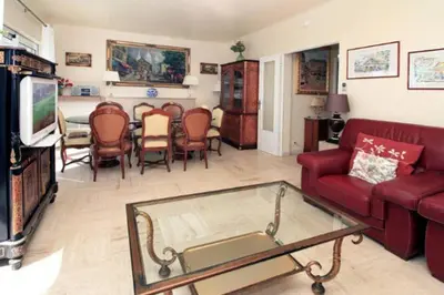 a living room with a red couch and a table at Villa piscine Eze bord de mer à 500m de la plage in Èze
