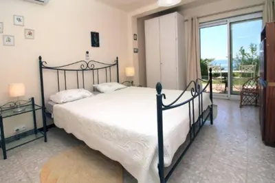 a bedroom with a large bed and a large window at Villa piscine Eze bord de mer à 500m de la plage in Èze