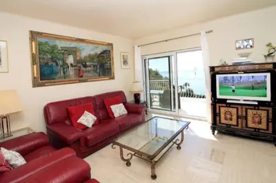a living room with a red couch and a tv at Villa piscine Eze bord de mer à 500m de la plage in Èze