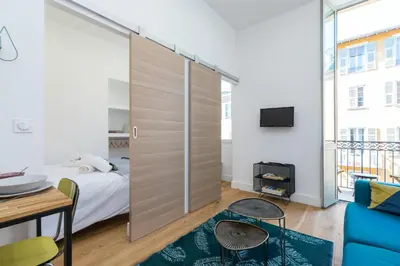 a bedroom with a sliding door with a bed and a table at Cosy 1 Bdr Place Garibaldi & Place du Pin in Nice