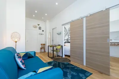 a living room with a blue couch and a sliding door at Cosy 1 Bdr Place Garibaldi & Place du Pin in Nice