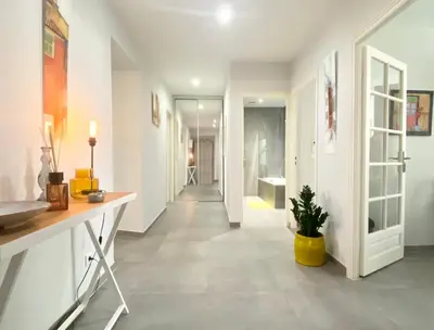 a hallway with white walls and a yellow pot on the floor at Cozy 2BR Appartment near the Port of Nice in Nice
