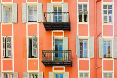 a facade of an orange building with white windows and balconies at Cozy 2BR Appartment near the Port of Nice in Nice