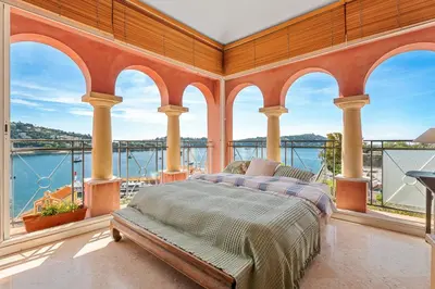 a bedroom with a bed and a view of the water at Penthouse La Bellevue in Villefranche-sur-Mer