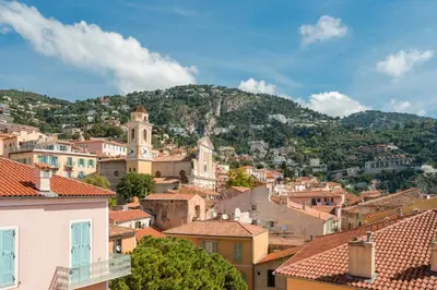 a view of a town with a mountain in the background at Penthouse La Bellevue in Villefranche-sur-Mer