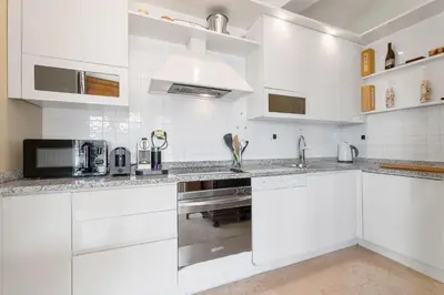 a white kitchen with white cabinets and a sink at Penthouse La Bellevue in Villefranche-sur-Mer