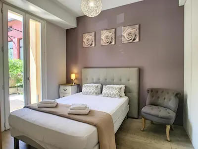 a bedroom with a large bed and a chair at Nestor&Jeeves - HOLIDAY VIBES - Very close sea - Free parking in Nice