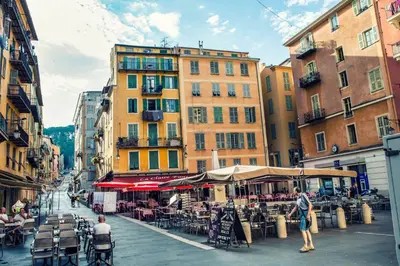 a city street with tables and chairs and buildings at Nestor&Jeeves - HOLIDAY VIBES - Very close sea - Free parking in Nice