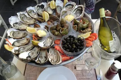a plate of oysters and vegetables on a table at Bienvenue sur la Cote d'Azur in Nice