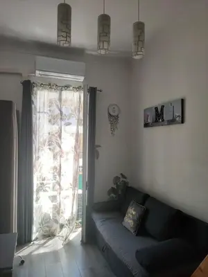 a living room with a couch and a large window at Bienvenue sur la Cote d'Azur in Nice