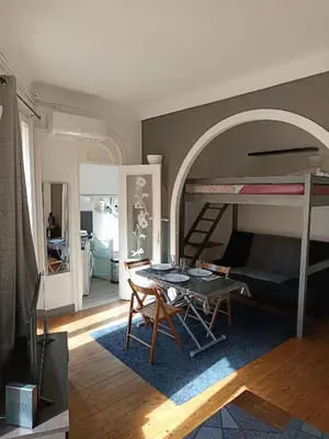 a living room with a table and a bunk bed at Charmant studio climatisé centre Villefranche sur mer in Villefranche-sur-Mer