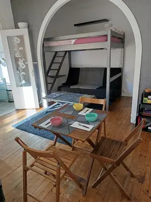 a room with a table and chairs and a bunk bed at Charmant studio climatisé centre Villefranche sur mer in Villefranche-sur-Mer