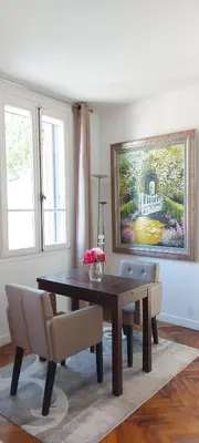 a dining room table with chairs and a painting on the wall at Villa Angelus in Nice