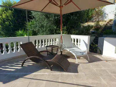 a patio with an umbrella and two chairs and a table at Villa Angelus in Nice
