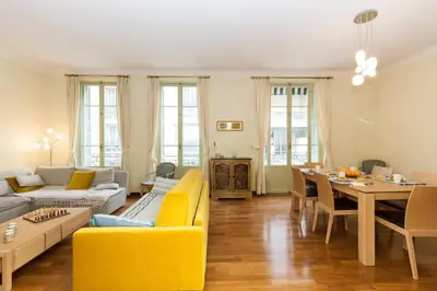 a living room with a yellow couch and a table at Le GIULIANO in Nice