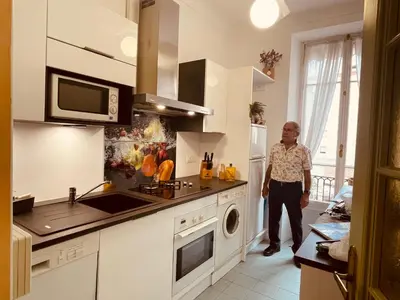 a man standing in a kitchen with a sink at Le GIULIANO in Nice