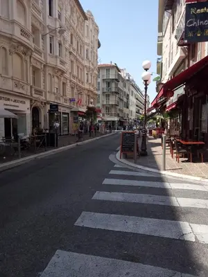 an empty street with a crosswalk in a city at Logement de Catherine in Nice
