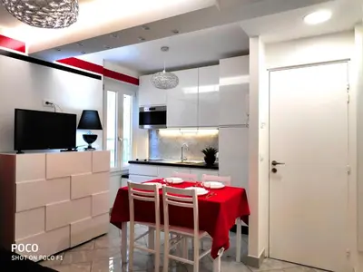 a kitchen with a table with a red table cloth at Logement de Catherine in Nice
