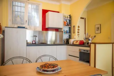 a kitchen with a table with a bowl of food on it at Joli 2 pièces climatisé à 150m de la plage in Nice