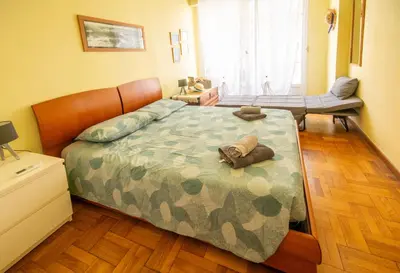 a bedroom with a bed with a camouflage bedspread at Joli 2 pièces climatisé à 150m de la plage in Nice