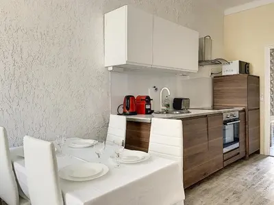 a kitchen with a table with white plates on it at 2-bedrooms аpartment Nice Port with parking in Nice