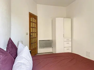 a bedroom with a bed with purple and white pillows at 2-bedrooms аpartment Nice Port with parking in Nice
