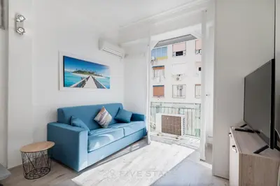 a living room with a blue couch and a tv at Studio Imperator Five stars holiday house in Nice