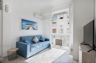 a living room with a blue couch and a tv at Studio Imperator Five stars holiday house in Nice