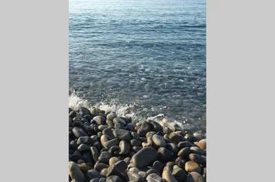 a group of rocks on a beach next to the water at CHARMANT HOME-Azur Charmant in Nice