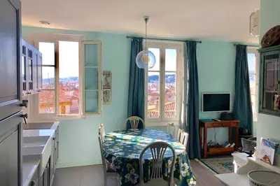 a kitchen with a table and two chairs in a room at CHARMANT HOME - Mariesol in Nice