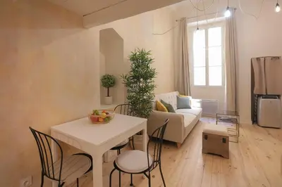 a living room with a table and chairs and a couch at Charmant Studio climatisé - Vieux Nice in Nice