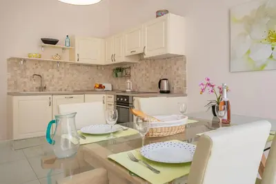 a kitchen with white cabinets and a table with plates and glasses at 