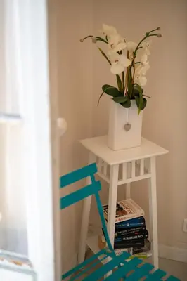 a white table with a vase of flowers on it at 