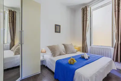 a bedroom with a bed with blue sheets and a mirror at MY CASA - GUISOL - Typical Nice 3 Bedroom AC near Port in Nice