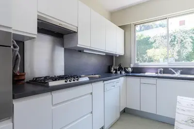 a white kitchen with white cabinets and a sink at Sea View Park Swimming Pool & Tennis 2 Bdrs in Villefranche-sur-Mer