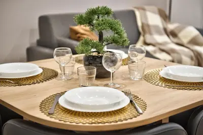 a wooden table with plates and wine glasses on it at Home Inn - Centre ville - Nice in Nice