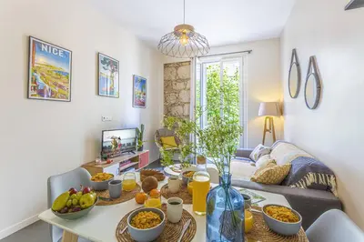 a living room with a table with food on it at MY CASA - GAMBETTA 33 - 5min walk to beach in Nice