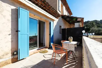a patio with a blue door and a table and chair at Observatoire in Nice