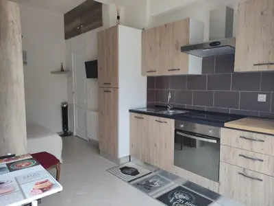 a kitchen with wooden cabinets and a stove top oven at L'Ambre d'Or in Falicon