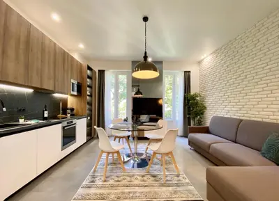 a kitchen and living room with a couch and a table at Maxim - Easy Home Booking in Nice