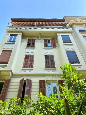 a tall white building with windows on it at Maxim - Easy Home Booking in Nice